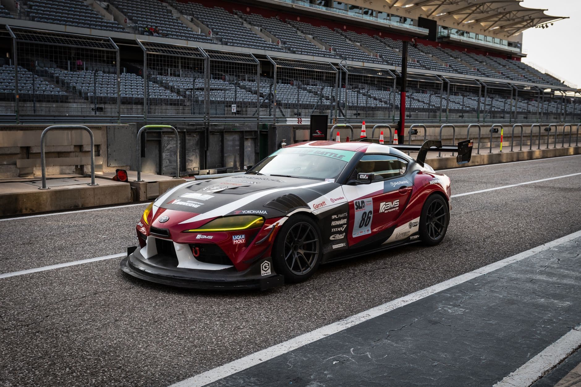 Toyota Supra parked on the Circuit of the Americas race track in Austin, TX, showcasing motorsport design.