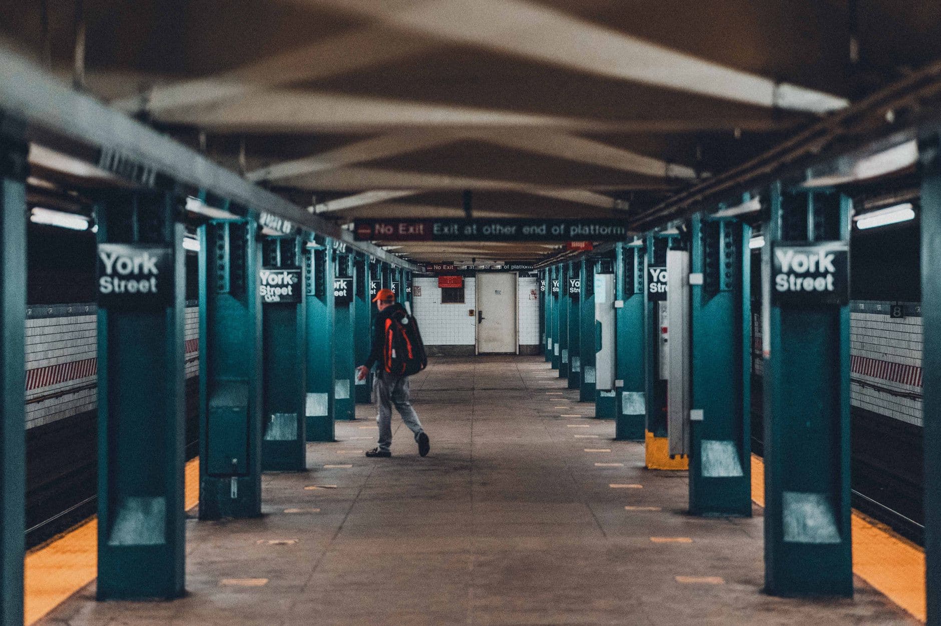 A candid shot of a man walking through York Street Subway Station in New York City.